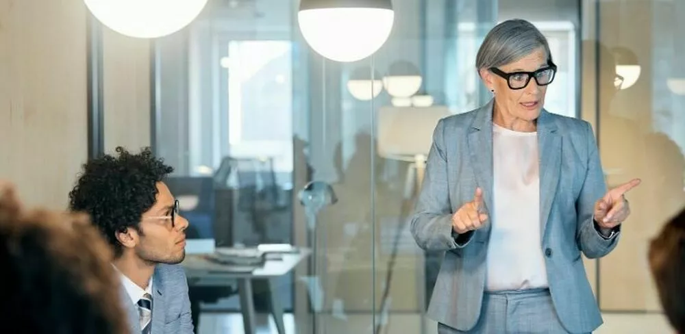 En dame snakker til en gruppe mennesker. Foto